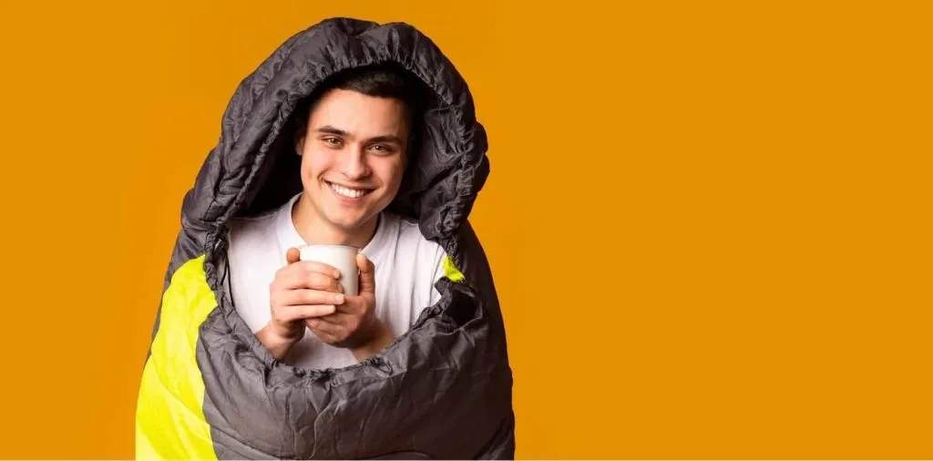 9 Best Teas For Relaxing and Better Sleep of 2025, Tried And Tested 1 Man in sleeping bag drinking tea Best Picks, Best Supplements